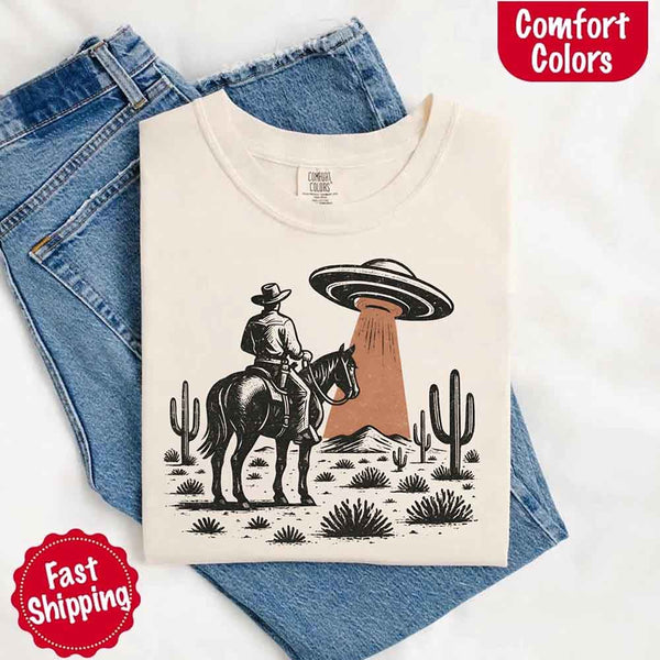 Retro cowboy and horse graphic with UFO beaming light in desert landscape with cacti – western alien mashup design