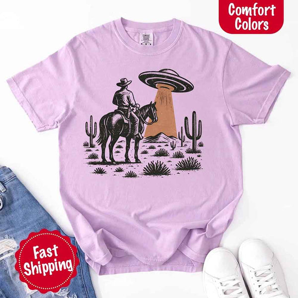 Retro cowboy and horse graphic with UFO beaming light in desert landscape with cacti – western alien mashup design