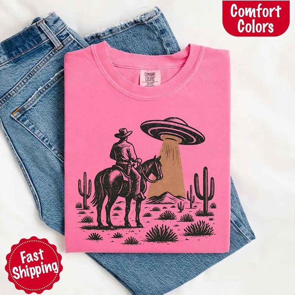 Retro cowboy and horse graphic with UFO beaming light in desert landscape with cacti – western alien mashup design