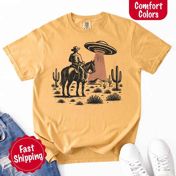 Retro cowboy and horse graphic with UFO beaming light in desert landscape with cacti – western alien mashup design