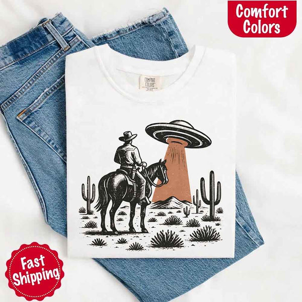 Retro cowboy and horse graphic with UFO beaming light in desert landscape with cacti – western alien mashup design