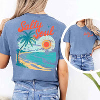 May include a short-sleeve t-shirt with “Salty Soul” printed in bold script on the front left chest and a large back graphic featuring a tropical beach scene with a palm tree, ocean waves, a bright orange sun, and flying birds.