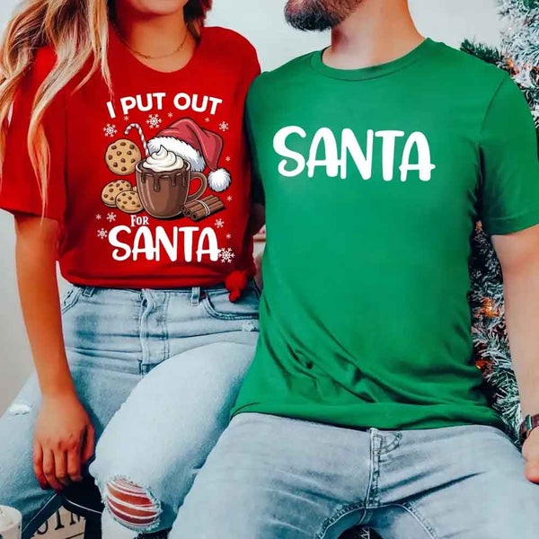May include a pair of matching Christmas couple shirts with a playful Santa phrase printed on the front, shown on a flat surface.
