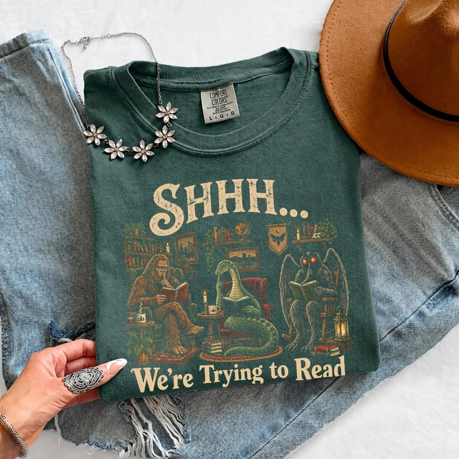 May include a Shhh We're Trying to Read Comfort Colors T-Shirt featuring a playful book lover statement design.