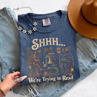 May include a Shhh We're Trying to Read Comfort Colors T-Shirt featuring a playful book lover statement design.