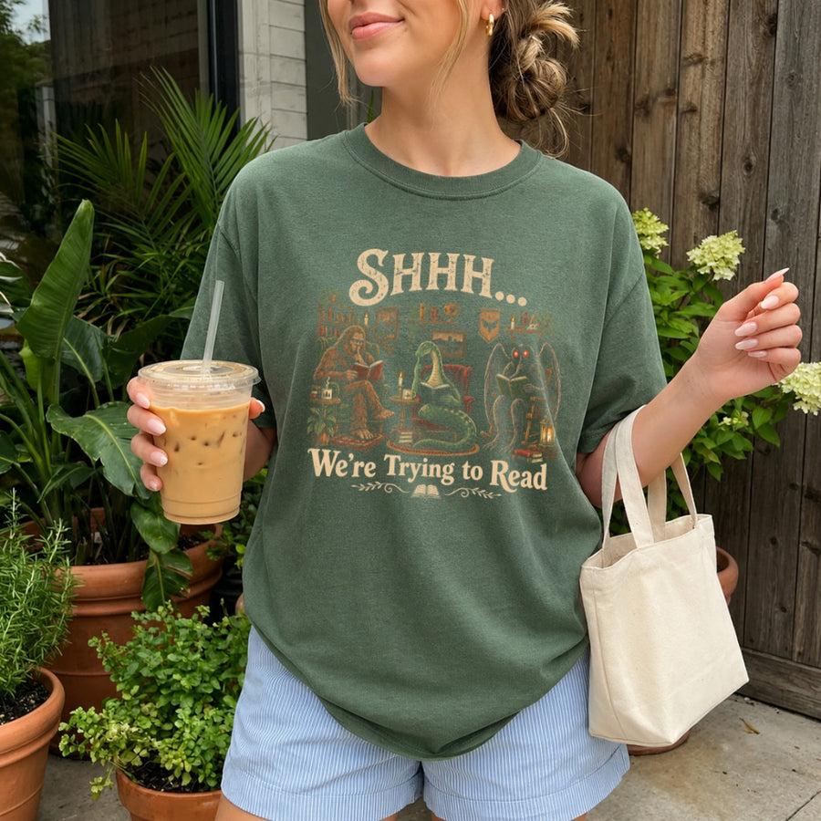 May include a Shhh We're Trying to Read Comfort Colors T-Shirt featuring a playful book lover statement design.