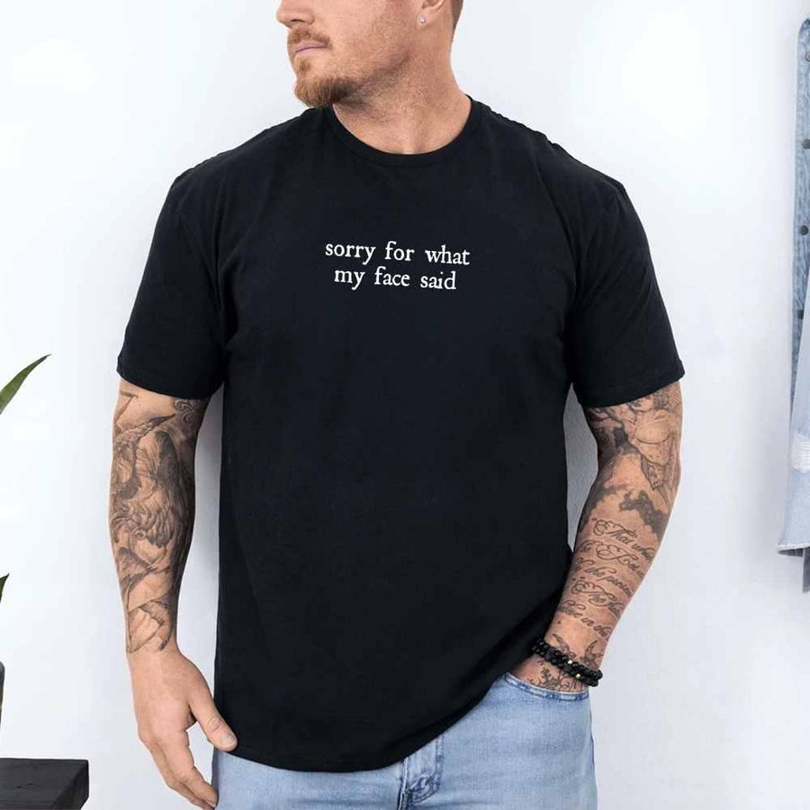 May include a person wearing a black funny graphic t-shirt reading “Sorry for What My Face Said”.
