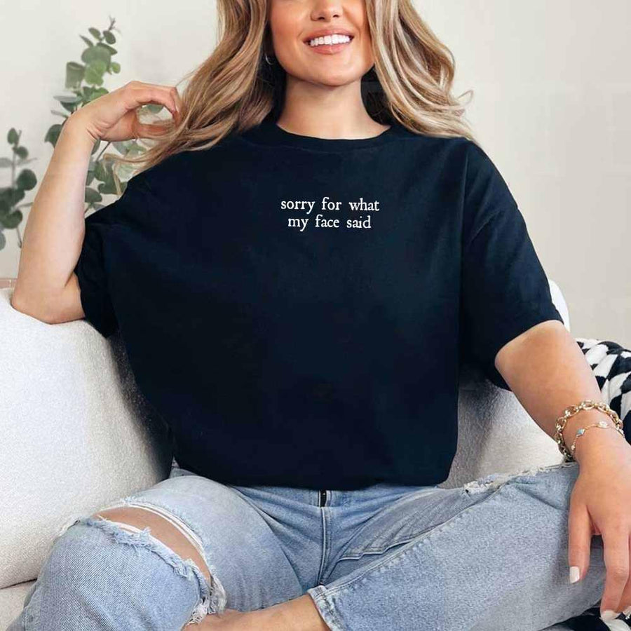 May include a person wearing a black funny graphic t-shirt reading “Sorry for What My Face Said”.