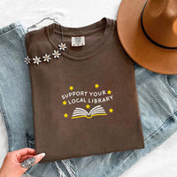 May include a Support Your Local Library Comfort Colors T-Shirt featuring a simple library-inspired statement design.