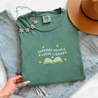 May include a Support Your Local Library Comfort Colors T-Shirt featuring a simple library-inspired statement design.