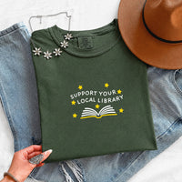 May include a Support Your Local Library Comfort Colors T-Shirt featuring a simple library-inspired statement design.