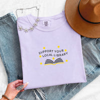 May include a Support Your Local Library Comfort Colors T-Shirt featuring a simple library-inspired statement design.