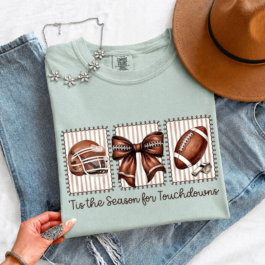 May include a Comfort Colors T-shirt featuring a 'Tis the Season for Touchdowns football-inspired design, perfect for football fans, game days, tailgates, and holiday gatherings.