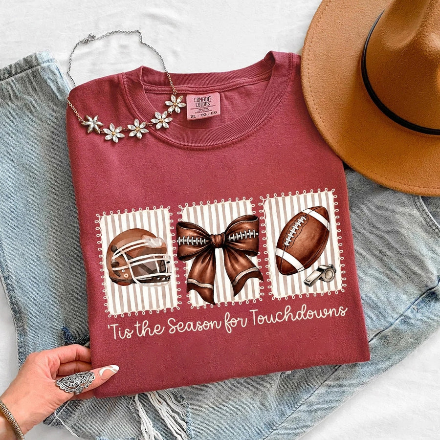 May include a Comfort Colors T-shirt featuring a 'Tis the Season for Touchdowns football-inspired design, perfect for football fans, game days, tailgates, and holiday gatherings.