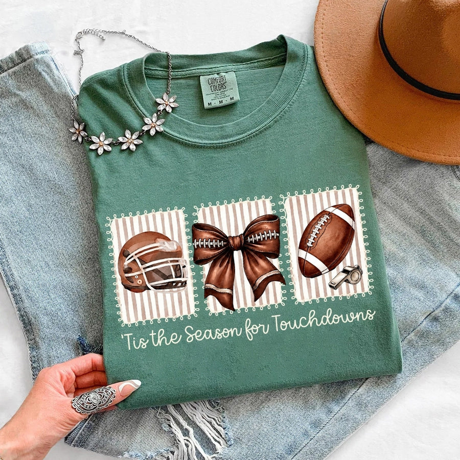 May include a Comfort Colors T-shirt featuring a 'Tis the Season for Touchdowns football-inspired design, perfect for football fans, game days, tailgates, and holiday gatherings.