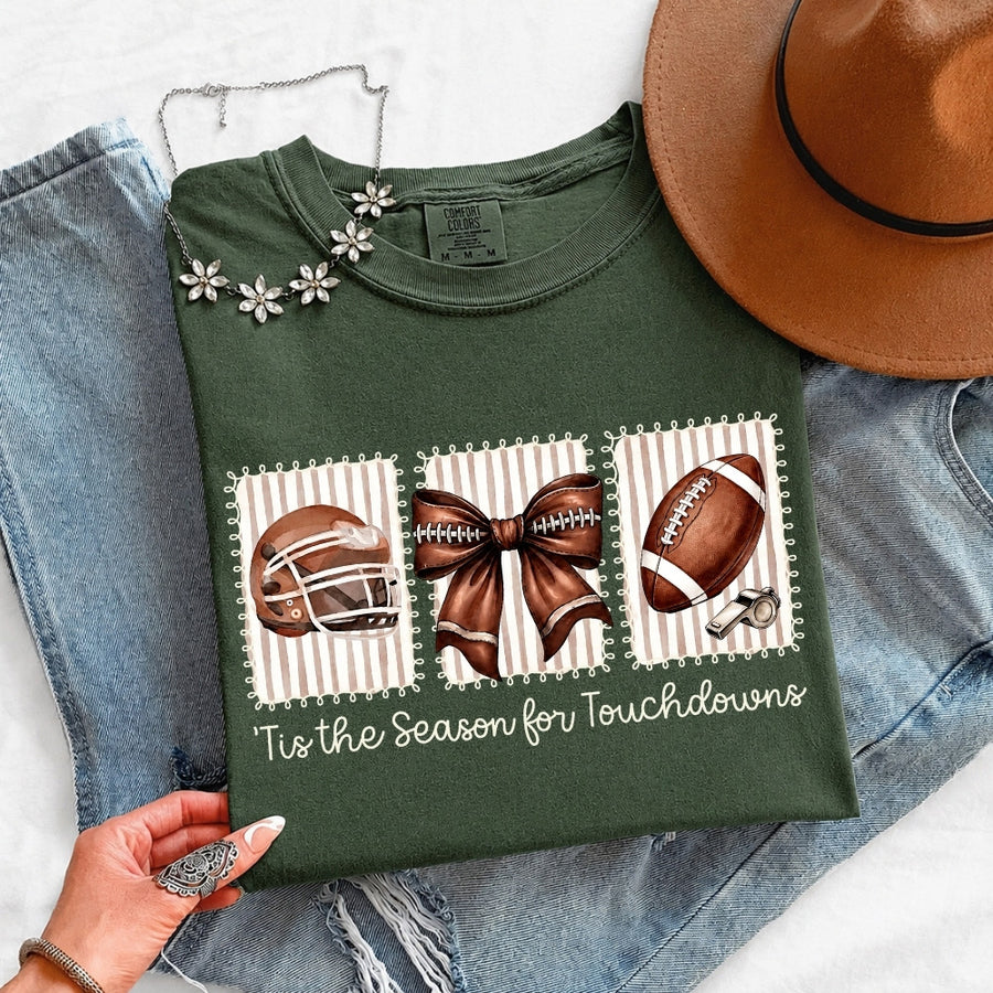 May include a Comfort Colors T-shirt featuring a 'Tis the Season for Touchdowns football-inspired design, perfect for football fans, game days, tailgates, and holiday gatherings.