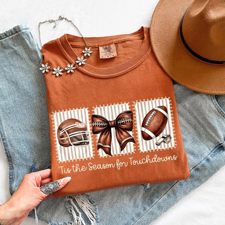May include a Comfort Colors T-shirt featuring a 'Tis the Season for Touchdowns football-inspired design, perfect for football fans, game days, tailgates, and holiday gatherings.