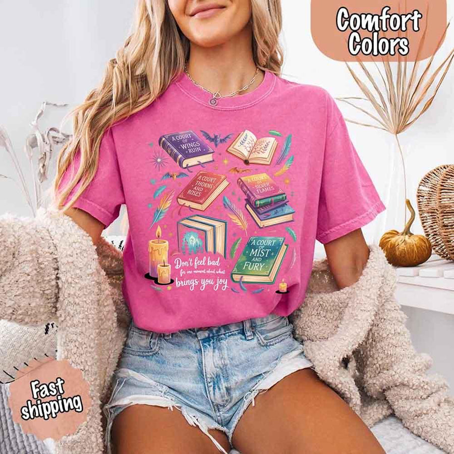 May include colorful illustrated books from the “A Court of Thorns and Roses” series surrounded by feathers, candles, and stars, with the quote “Don’t feel bad for one moment about what brings you joy,” celebrating fantasy fiction and book lover pride.