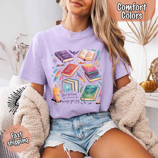 May include colorful illustrated books from the “A Court of Thorns and Roses” series surrounded by feathers, candles, and stars, with the quote “Don’t feel bad for one moment about what brings you joy,” celebrating fantasy fiction and book lover pride.