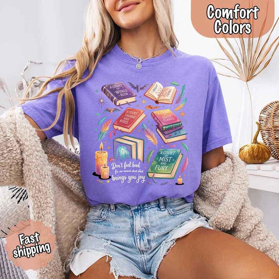 May include colorful illustrated books from the “A Court of Thorns and Roses” series surrounded by feathers, candles, and stars, with the quote “Don’t feel bad for one moment about what brings you joy,” celebrating fantasy fiction and book lover pride.