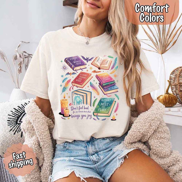 May include colorful illustrated books from the “A Court of Thorns and Roses” series surrounded by feathers, candles, and stars, with the quote “Don’t feel bad for one moment about what brings you joy,” celebrating fantasy fiction and book lover pride.