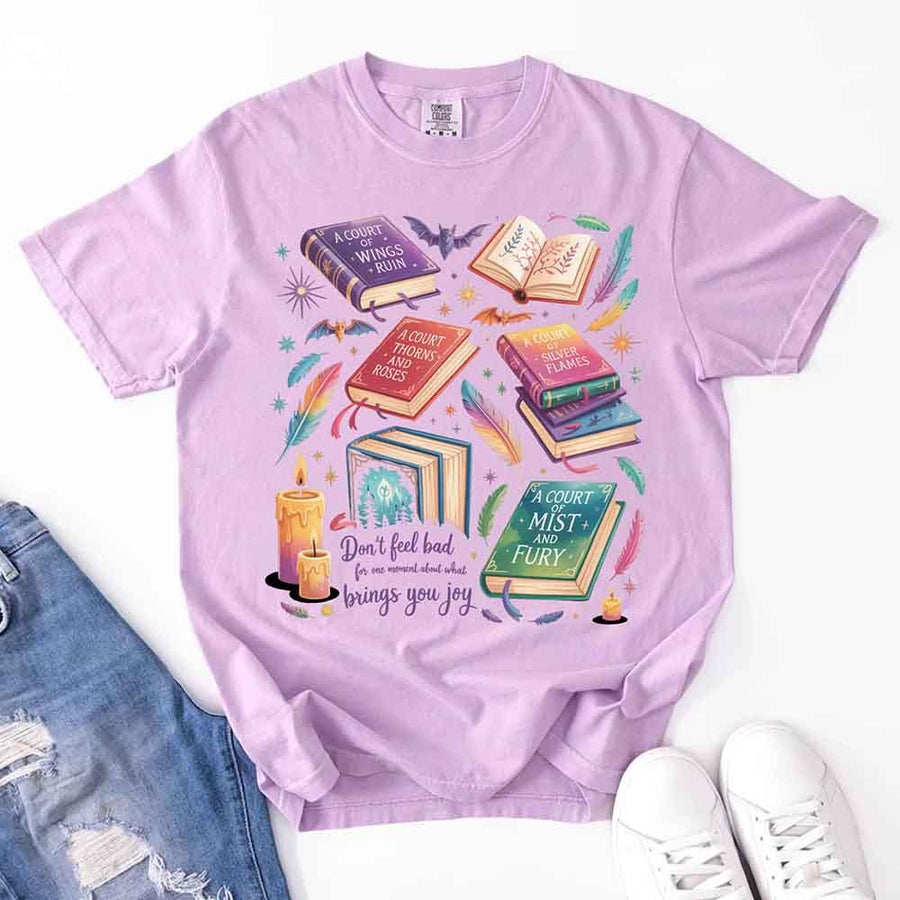 May include colorful illustrated books from the “A Court of Thorns and Roses” series surrounded by feathers, candles, and stars, with the quote “Don’t feel bad for one moment about what brings you joy,” celebrating fantasy fiction and book lover pride.