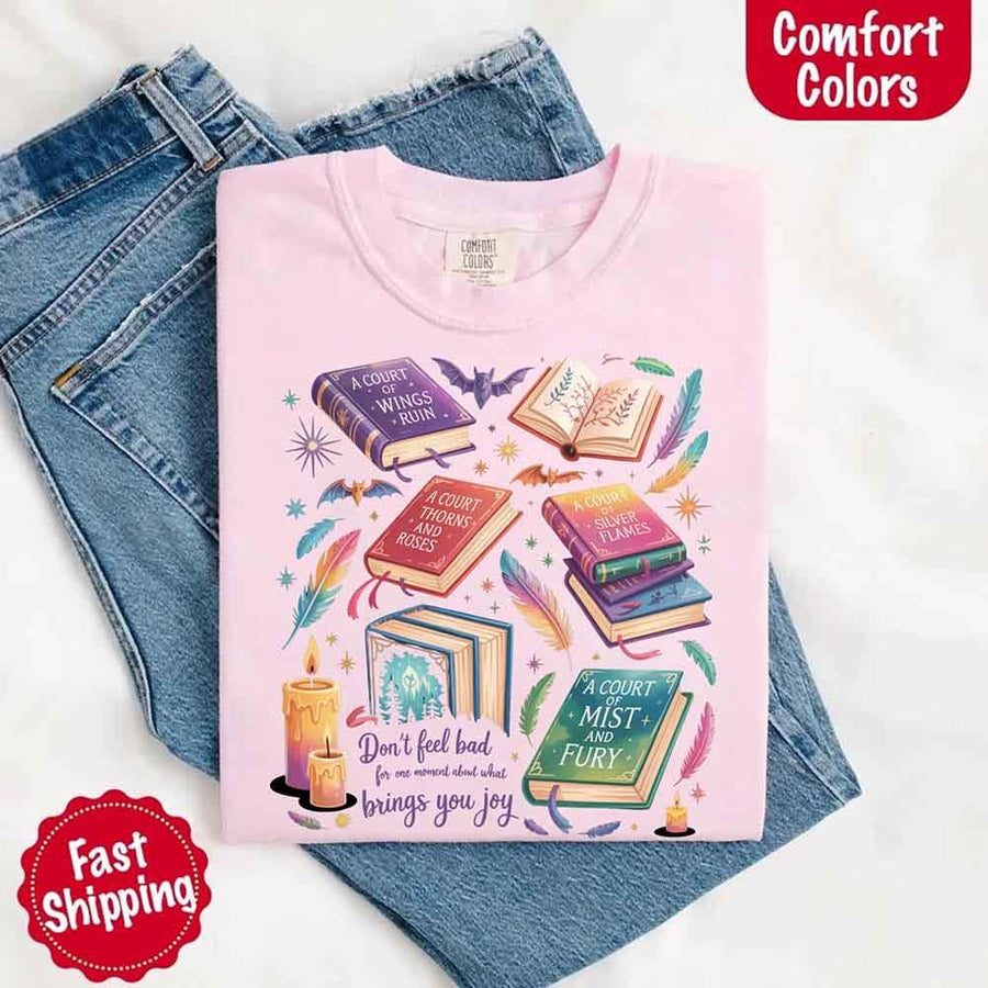 May include colorful illustrated books from the “A Court of Thorns and Roses” series surrounded by feathers, candles, and stars, with the quote “Don’t feel bad for one moment about what brings you joy,” celebrating fantasy fiction and book lover pride.