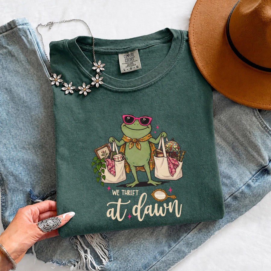 May include a We Thrift at Dawn Comfort Colors T-Shirt featuring a playful thrift-inspired statement design.