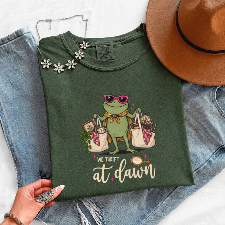May include a We Thrift at Dawn Comfort Colors T-Shirt featuring a playful thrift-inspired statement design.