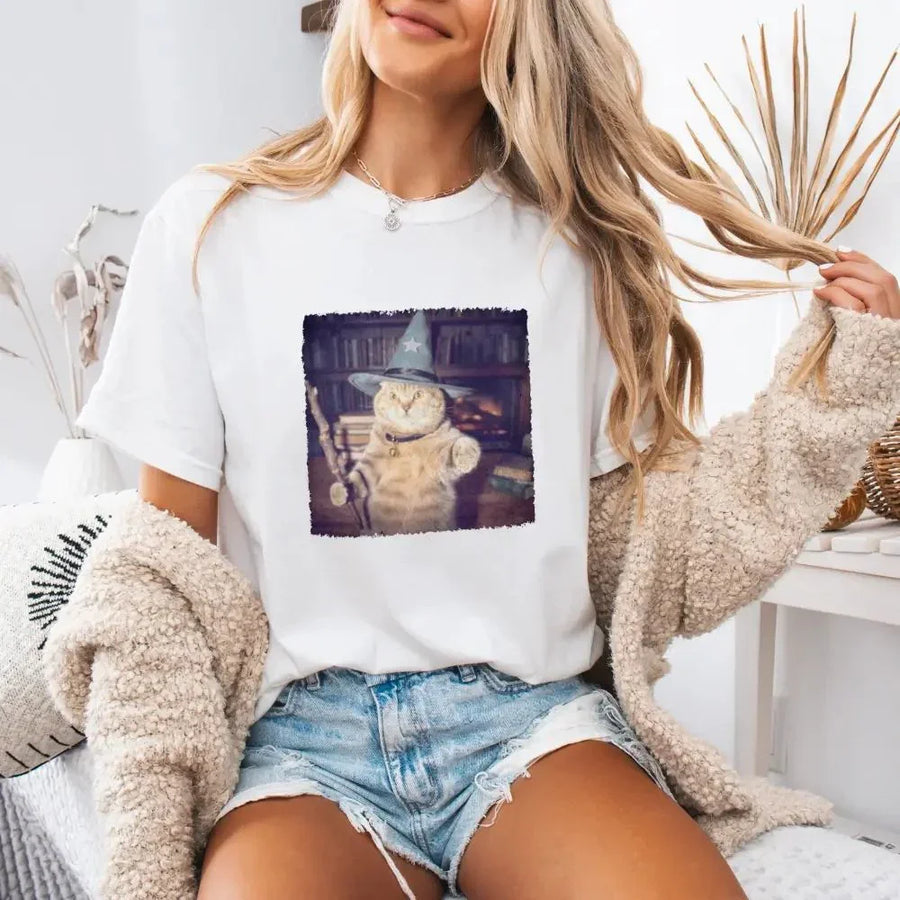 May include a Halloween t-shirt with a funny wizard cat meme graphic, combining magical and spooky design elements for cat lovers.