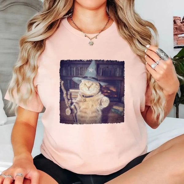 May include a Halloween t-shirt with a funny wizard cat meme graphic, combining magical and spooky design elements for cat lovers.