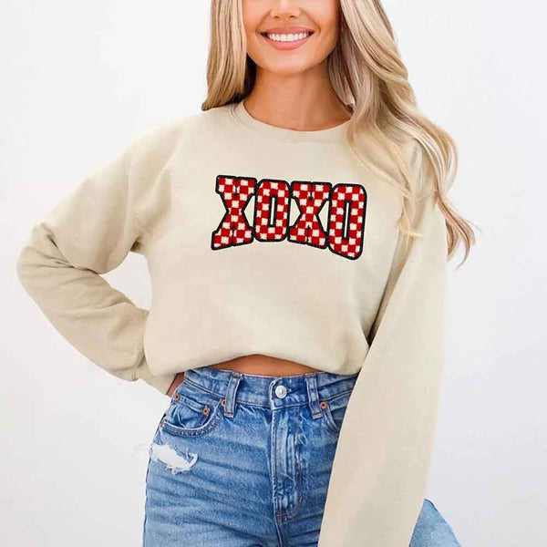 May include a crewneck sweatshirt with an XOXO checkered design featuring a soft, furry-style printed texture.