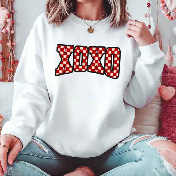 May include a crewneck sweatshirt with an XOXO checkered design featuring a soft, furry-style printed texture.