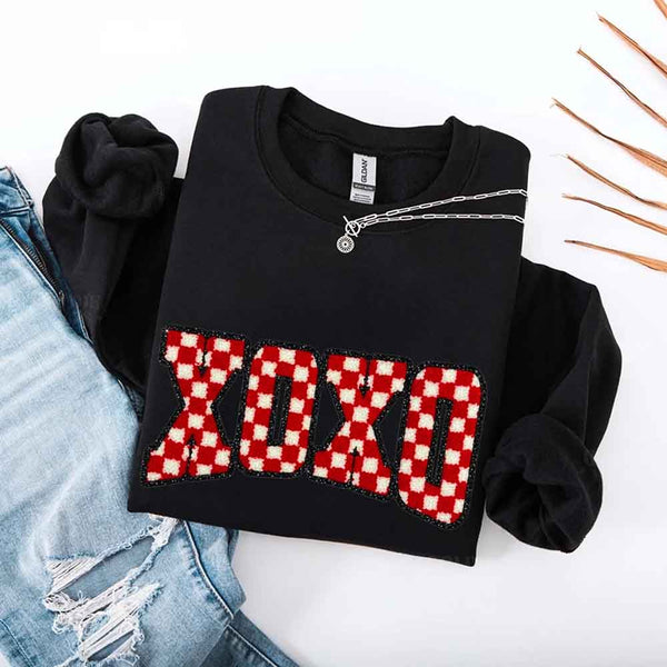 May include a crewneck sweatshirt with an XOXO checkered design featuring a soft, furry-style printed texture.