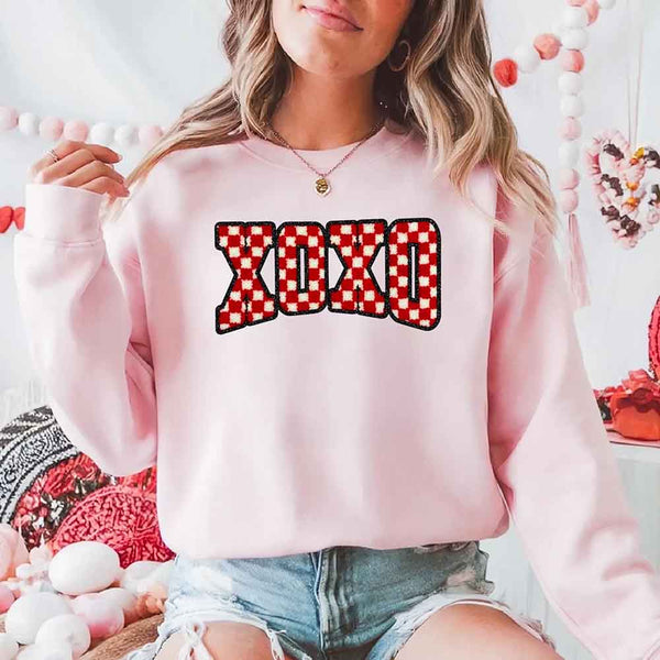 May include a crewneck sweatshirt with an XOXO checkered design featuring a soft, furry-style printed texture.