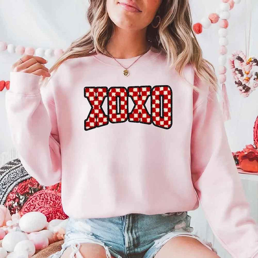 May include a crewneck sweatshirt with an XOXO checkered design featuring a soft, furry-style printed texture.