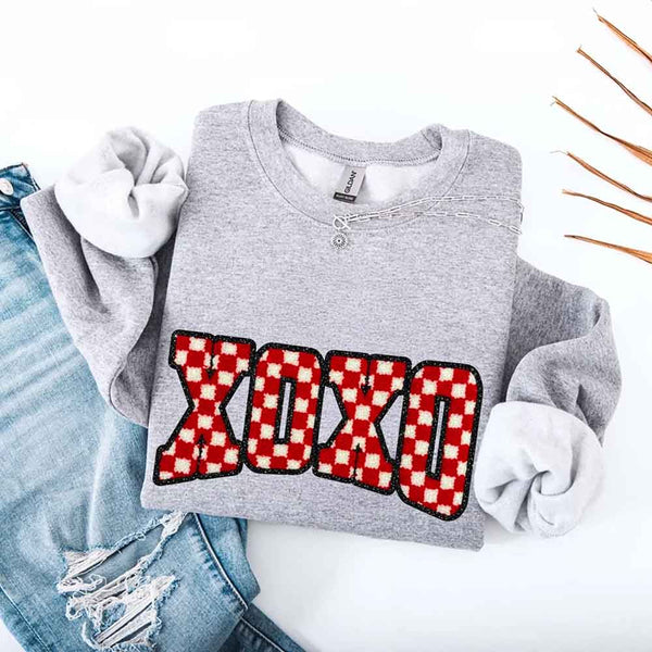May include a crewneck sweatshirt with an XOXO checkered design featuring a soft, furry-style printed texture.