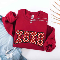 May include a crewneck sweatshirt with an XOXO checkered design featuring a soft, furry-style printed texture.