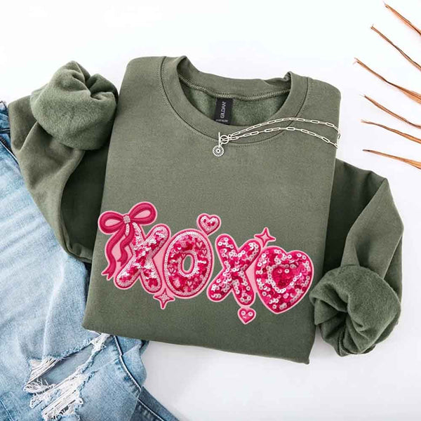 May include a crewneck sweatshirt featuring an XOXO design with a faux printed sequin appearance on the front.