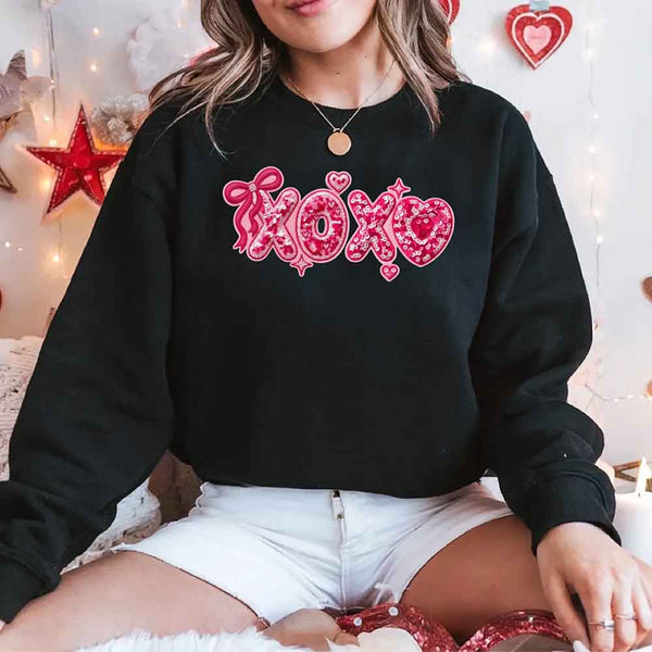 May include a crewneck sweatshirt featuring an XOXO design with a faux printed sequin appearance on the front.