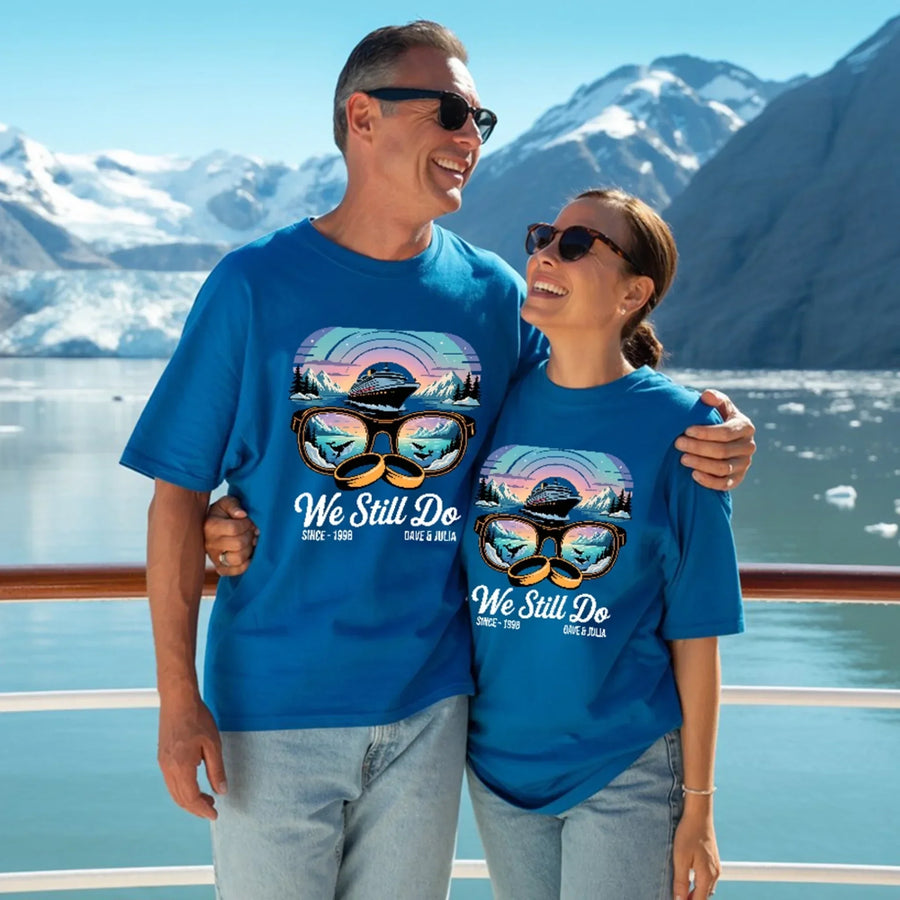 Smiling couple wearing matching blue personalized Alaska adventure anniversary t-shirts outdoors