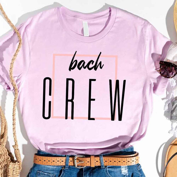 Lavender t-shirt with 'bach CREW' text, worn with denim jeans and a brown belt.