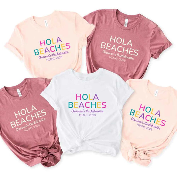 May include colorful “Bride Tribe” beach bachelorette T-shirts worn by a group of women, vibrant summer tones, seaside backdrop, fun party vibe, coordinated bridal crew outfits celebrating together!