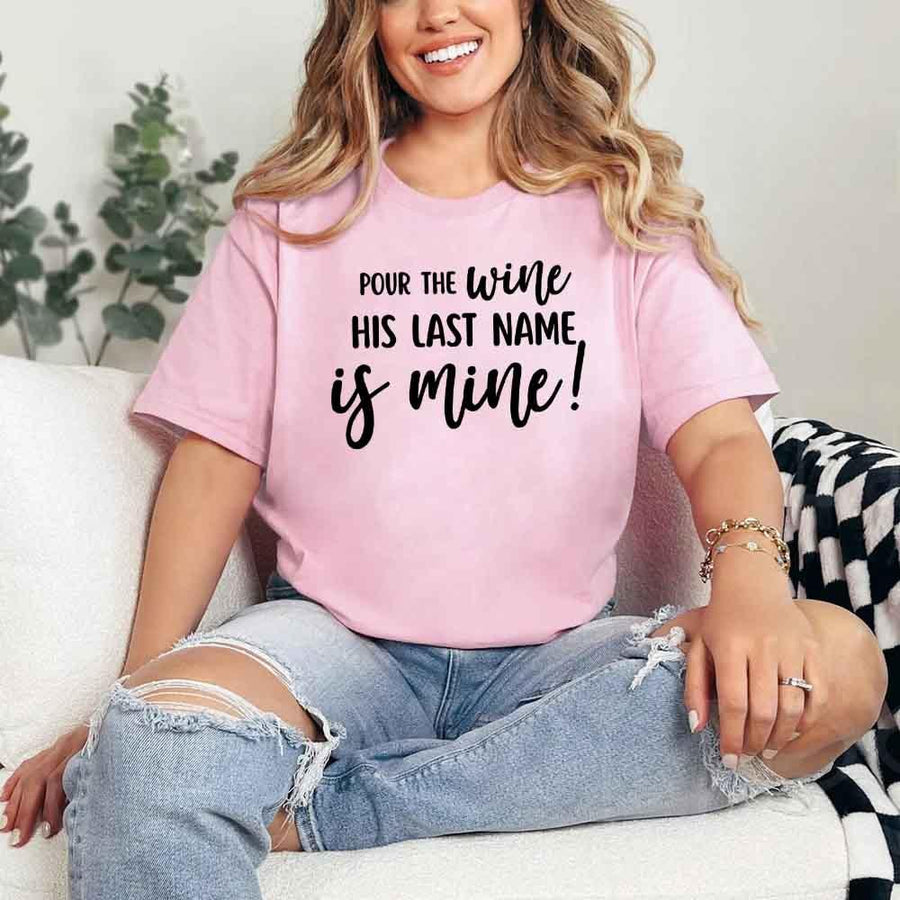 May include Pink Bachelorette Party Shirt with "Pour The Wine His Last Name Is Mine" T-Shirt design, perfect for bridal celebrations, fun nights, and making a statement!