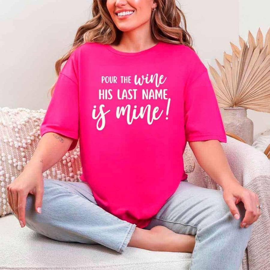 May include Heliconia Bachelorette Party Shirt with "Pour The Wine His Last Name Is Mine" T-Shirt design, perfect for bridal celebrations, fun nights, and making a statement!
