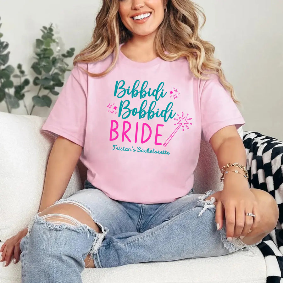 May include Pink a personalized Bibbidi Bobbidi Bride T-shirt with fairytale bridal lettering for a bachelorette party or wedding celebration.