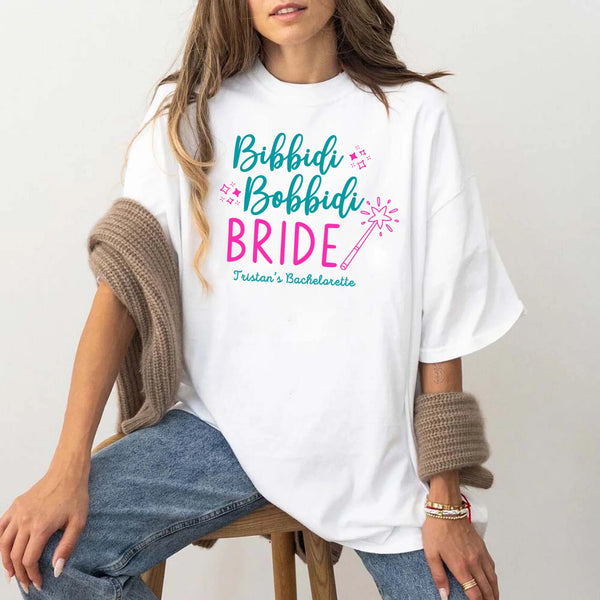 May include White a personalized Bibbidi Bobbidi Bride T-shirt with fairytale bridal lettering for a bachelorette party or wedding celebration.