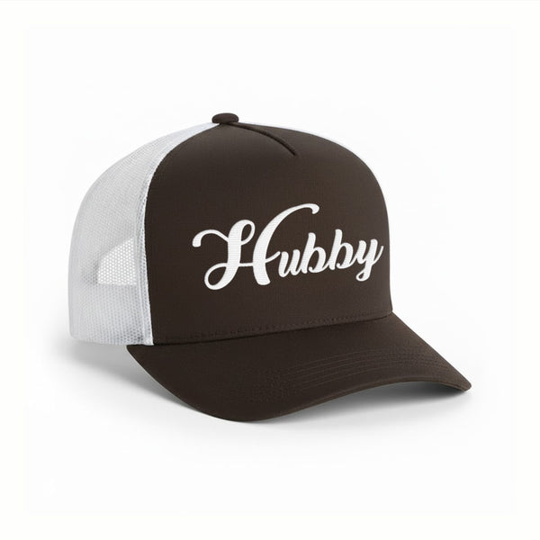 May include an embroidered trucker hat featuring the word “Hubby” stitched in clean, classic lettering on the front panel, designed with a structured crown and breathable mesh back for a timeless wedding or anniversary accessory.
