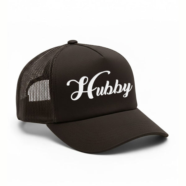 May include an embroidered trucker hat featuring the word “Hubby” stitched in clean, classic lettering on the front panel, designed with a structured crown and breathable mesh back for a timeless wedding or anniversary accessory.