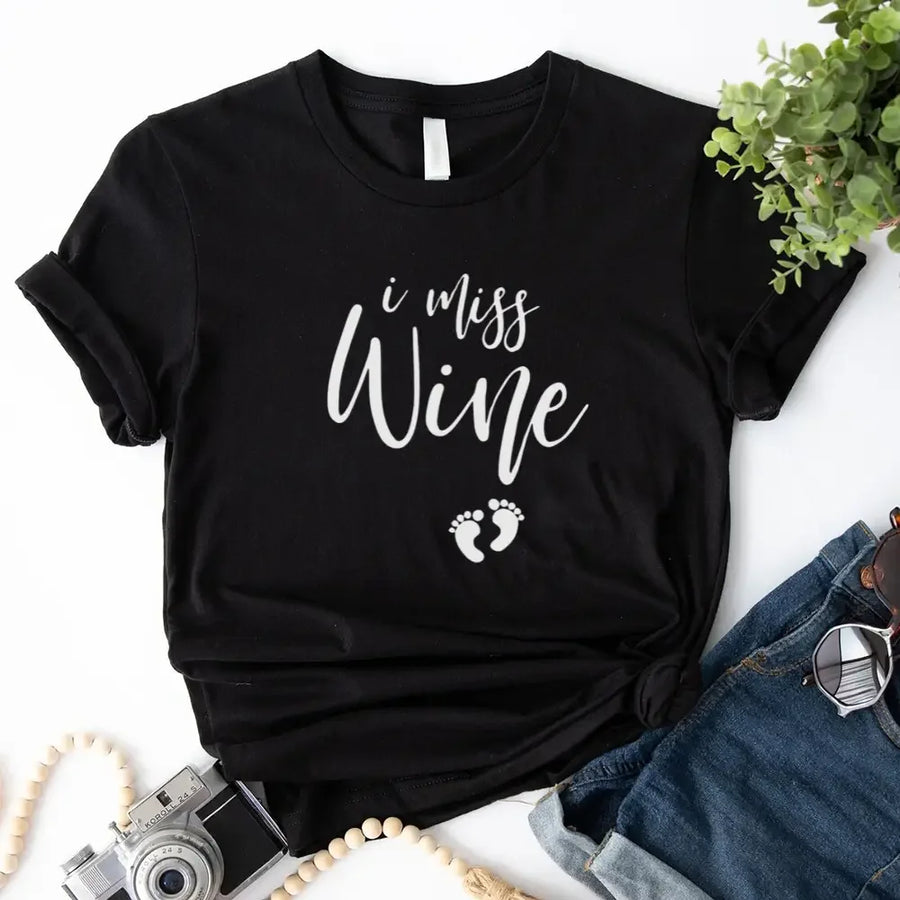 Black custom tee with 'I miss wine' text and baby footprints, styled with denim shorts.